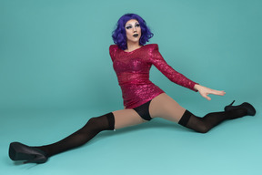 Drag queen in pink sequin dress doing the splits