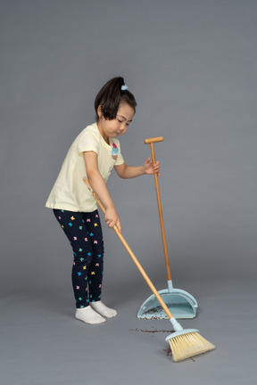 Side view of a little girl sweeping