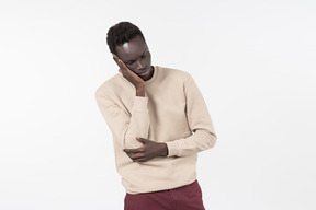 A young black man in a grey sweater standing alone on the white background