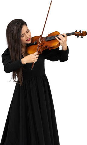 Close-up of a young emotional lady in black dress playing the violin