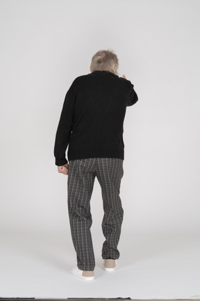 Back view of old man stepping and gesturing