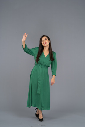 Front view of a greeting young lady in green dress