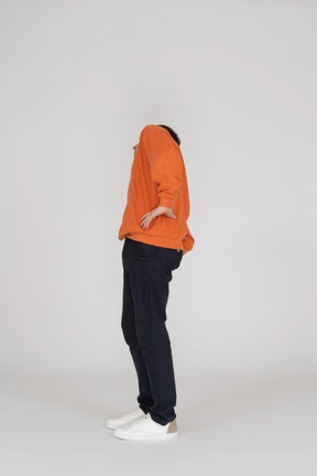 Young man in orange sweatshirt posing