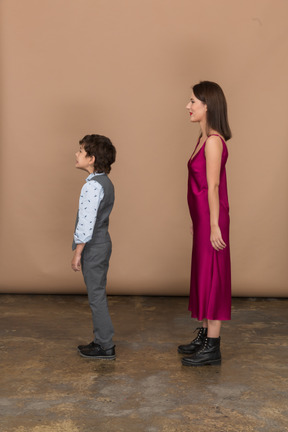 Boy and woman standing still in profile