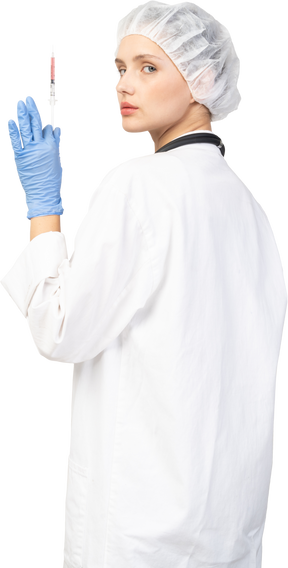 Vista posteriore di tre quarti di una giovane dottoressa che tiene in mano una siringa