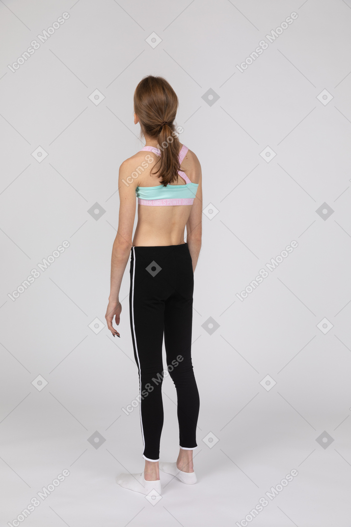 Vista traseira de uma adolescente em roupas esportivas jogando a cabeça para trás