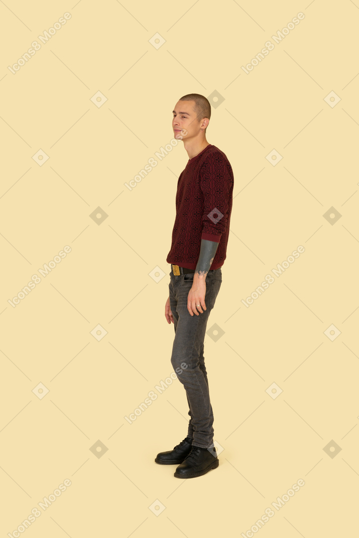 Вид спереди стоящего молодого человека в красном пуловере