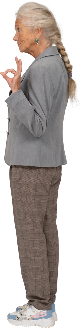 Vista laterale di una donna anziana in giacca grigia che mostra segno ok