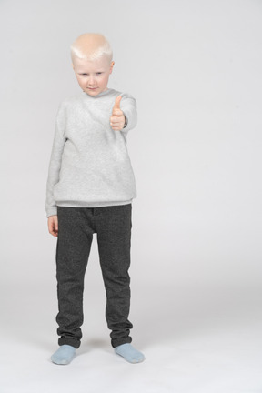 Boy in casual clothes showing thumb up