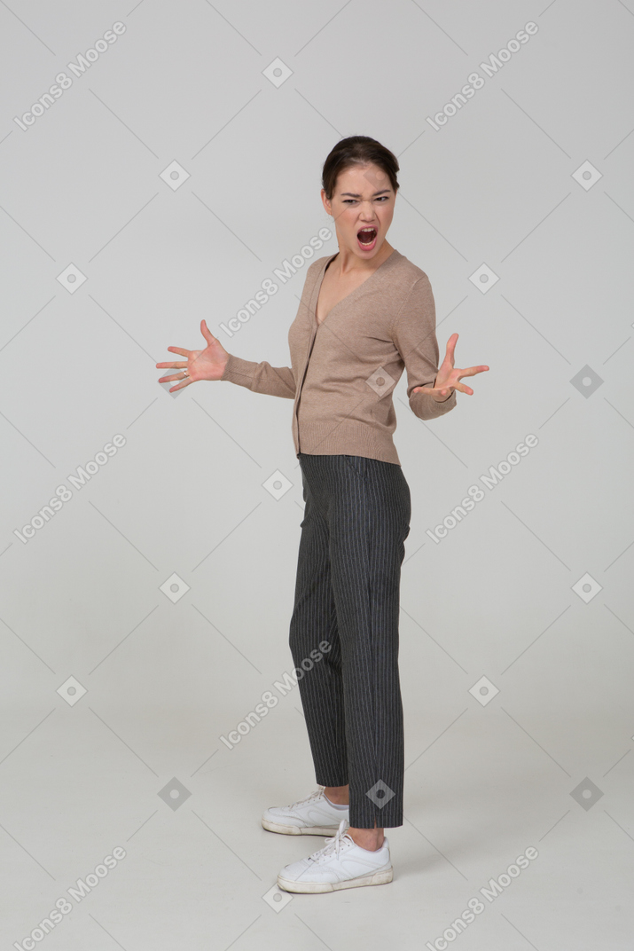 Vista di tre quarti di una giovane donna interrogativa gesticolante in pullover beige