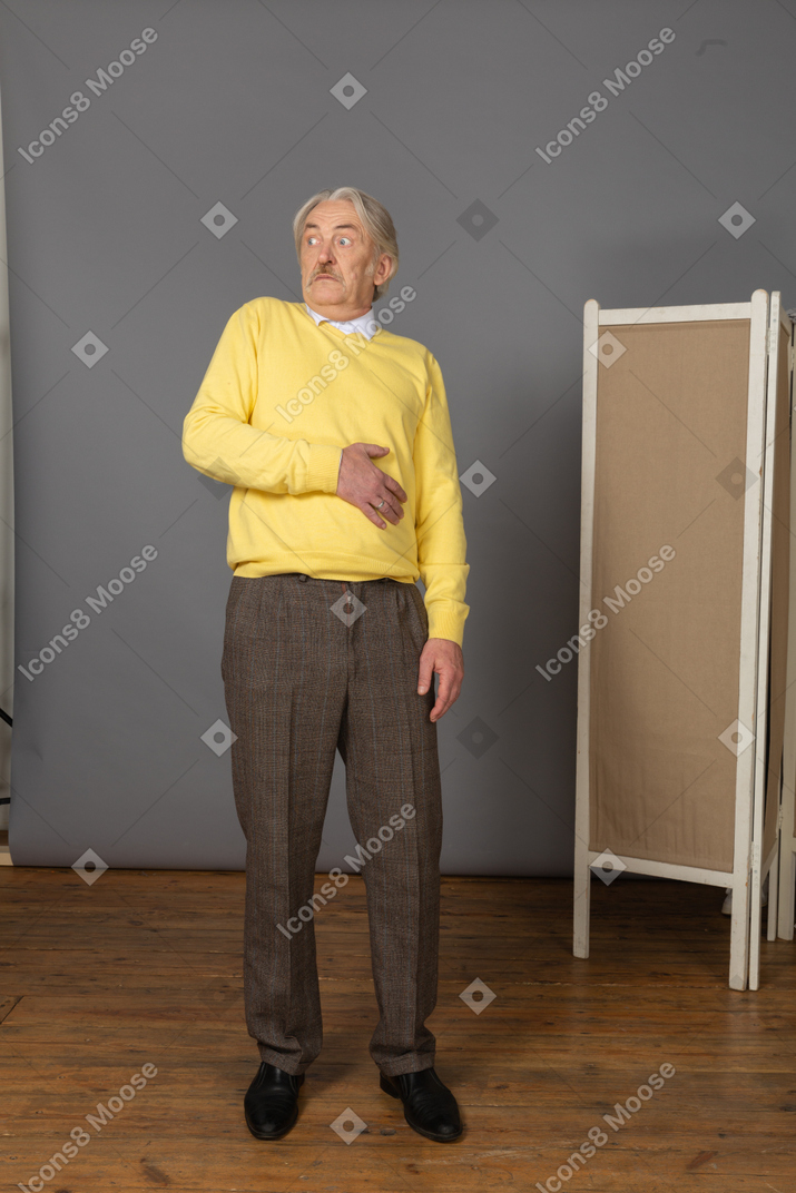 Front view of an old scared man leaning back