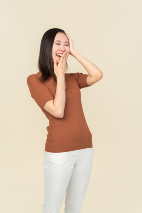 Rire jeune femme fermant la bouche avec une main