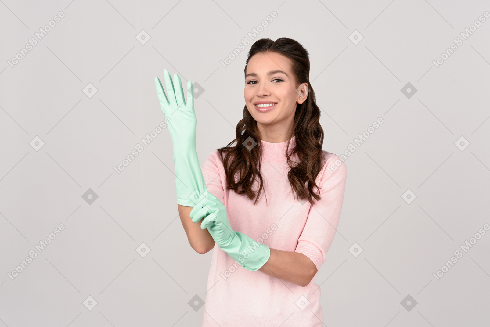 Attractive young woman putting on cleaning gloves