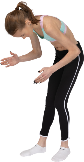 Three-quarter view of a teen girl in sportswear bending over and raising her hands