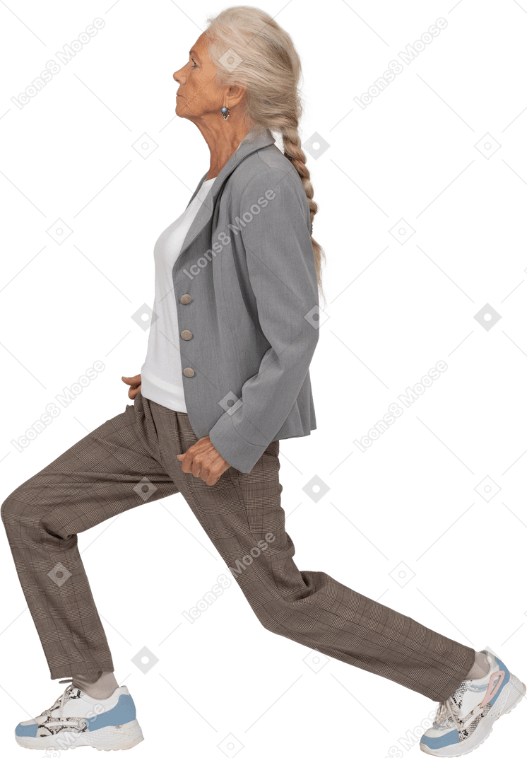 Side view of an old lady in suit doing forward lunges