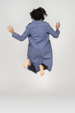 Vista traseira de uma mulher pulando