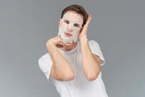 Front view of a young man posing in facial mask