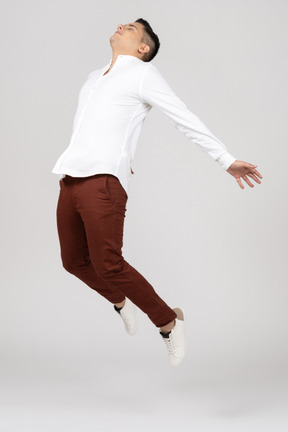 Three-quarter view of a young latino man stretching in the air