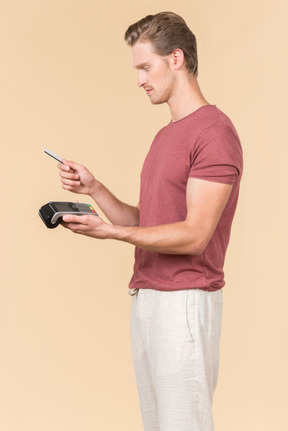 Young guy using a payment terminal