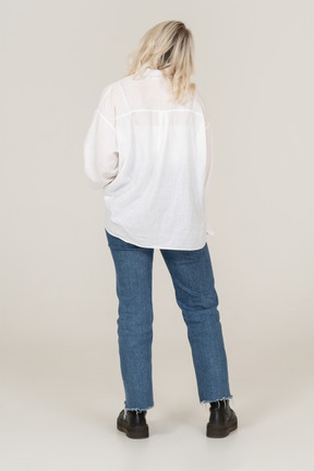 Back view of a blonde female in casual clothes  tilting head