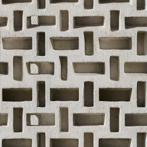 Parede de concreto com orifícios geométricos