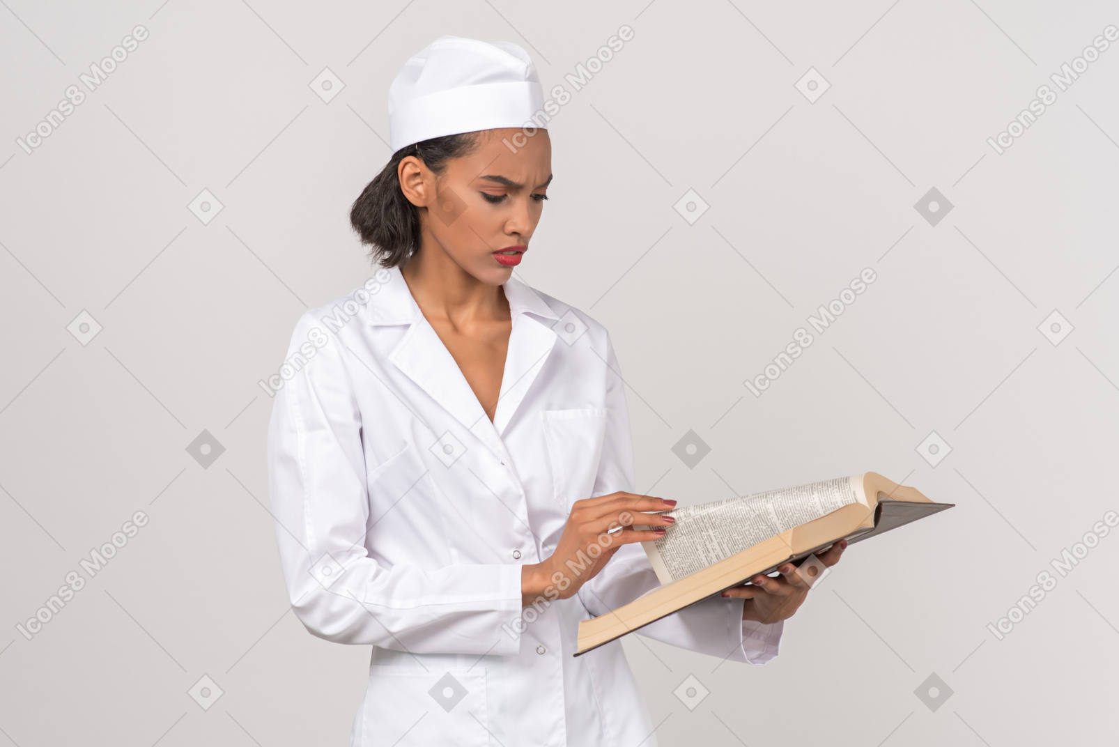 Привлекательная женщина-врач ищет что-то в книге