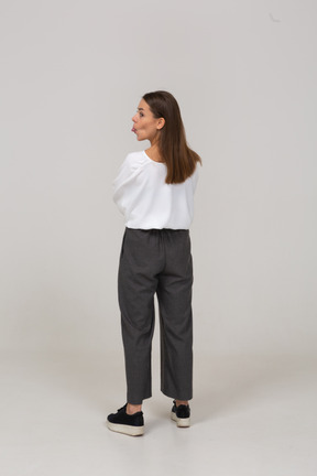 Vista traseira de uma jovem com roupa de escritório, mostrando a língua