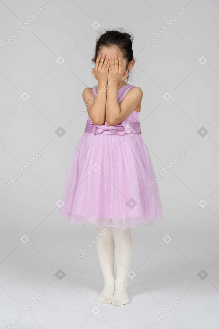 두 손으로 얼굴을 감싼 핑크색 드레스를 입은 소녀