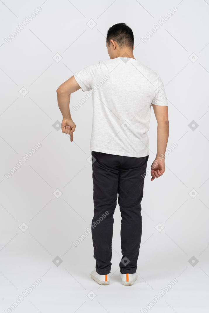 Vista traseira de um homem em roupas casuais, apontando para baixo