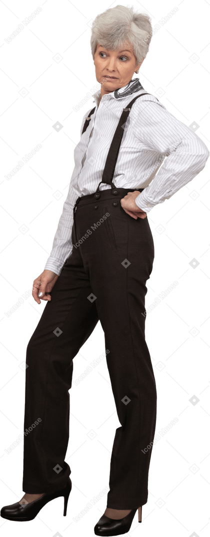 Side view of a displeased old lady in office clothing putting hand on hip