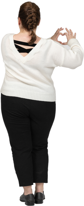 Plump woman in casual clothes showing heart figure with fingers
