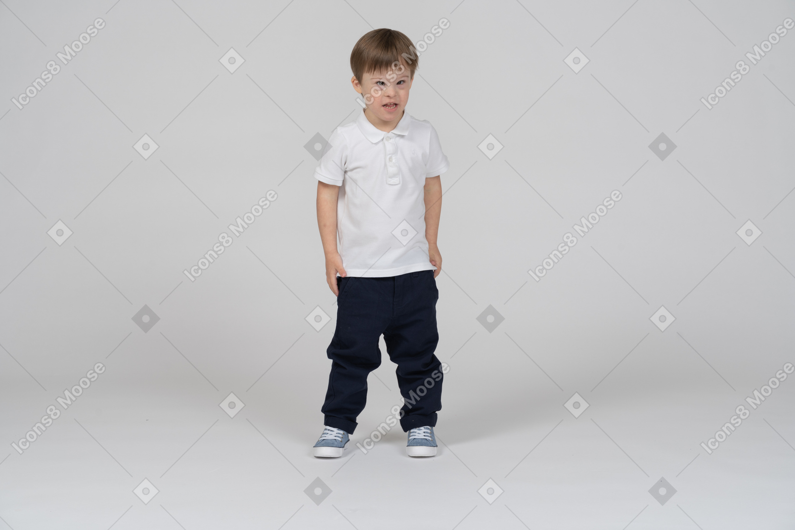 Vista frontal de um menino de pé e ligeiramente semicerrado