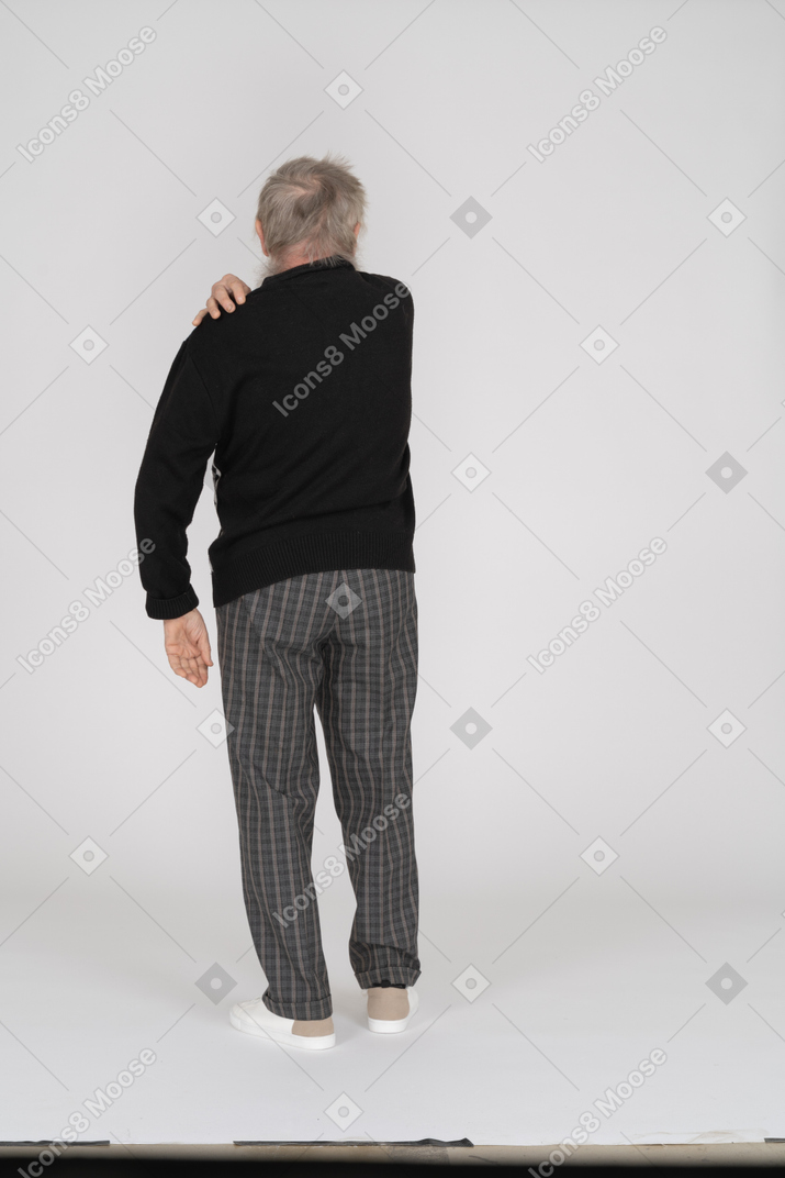 Back view of an old man touching his shoulder