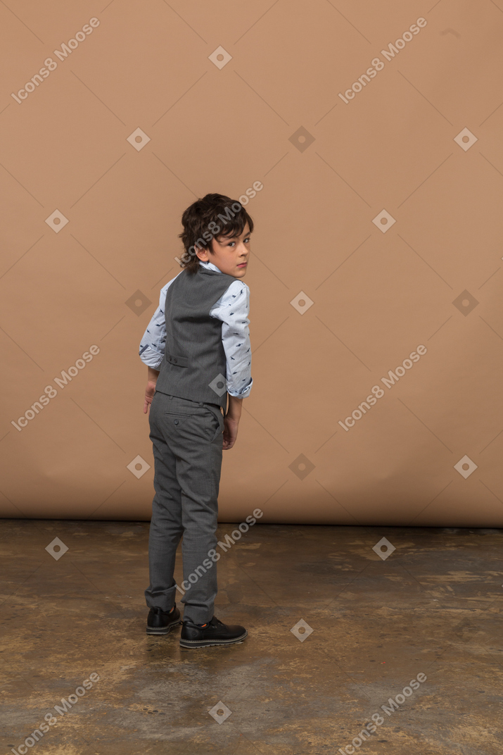 灰色のスーツを着た少年の背面図