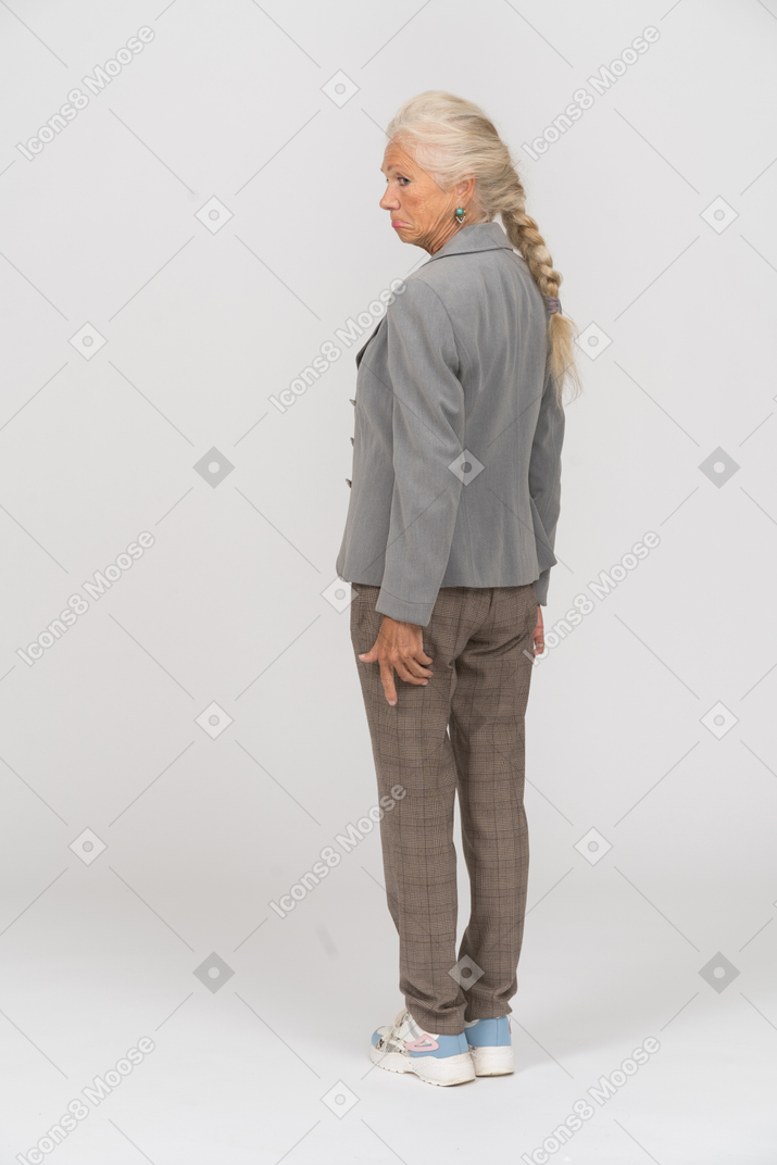 Old lady in grey jacket standing in profile