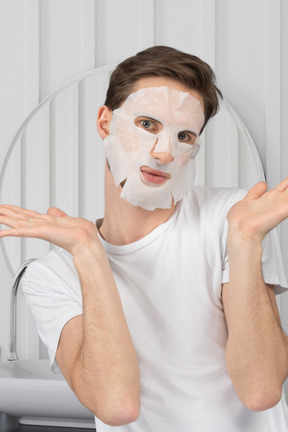 A man with a facial mask in a bathroom
