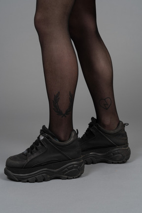 Vista lateral de las piernas en negro apretado y botas