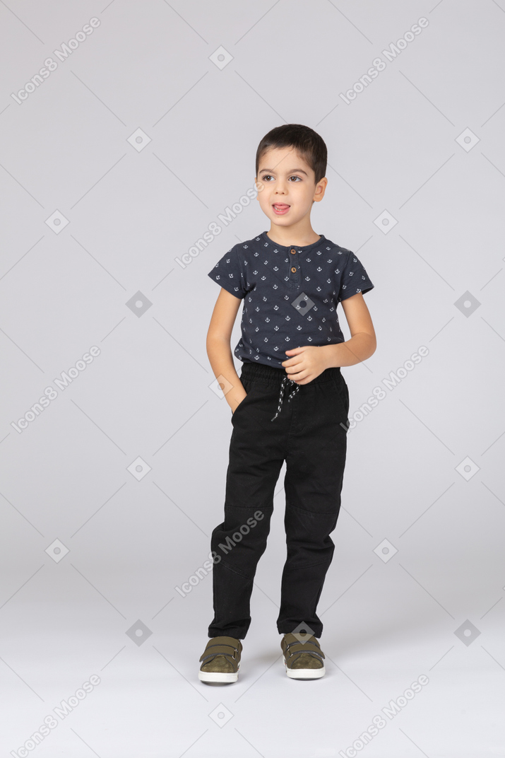 一个穿着休闲服的可爱男孩的前视图，手插在口袋里