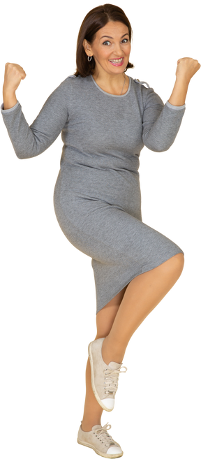 Vista frontal de uma mulher feliz em um vestido cinza