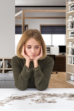 A woman sitting at a table in front of a puzzle