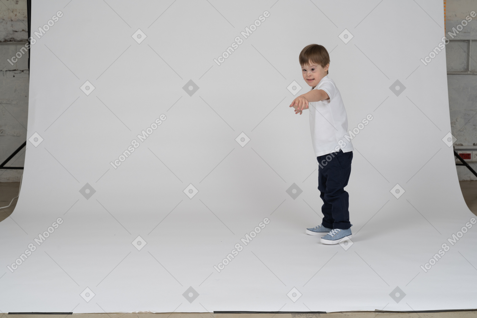 Side view of a boy reaching out his hand