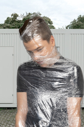 Young man wrapped in plastic