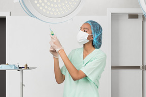 A woman in scrubs and a surgical mask