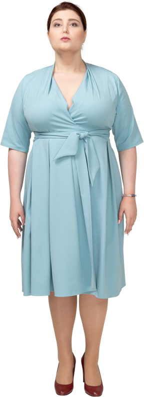 Vue de face d'une femme en robe bleue regardant la caméra