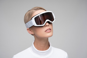 Jeune femme blonde en lunettes de ski voyant la réalité dans différentes dimensions