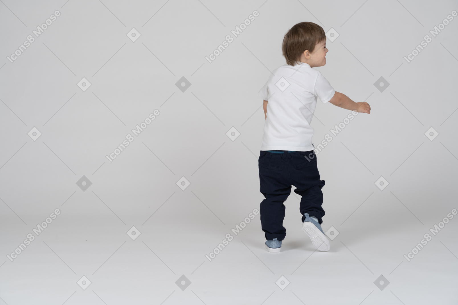 Back view of a boy stepping forward and smiling to the side