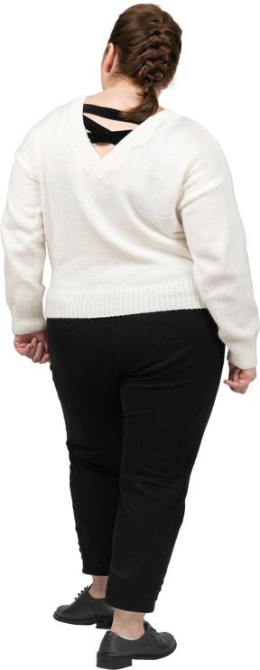 Пухлая женщина в белом свитере стоит
