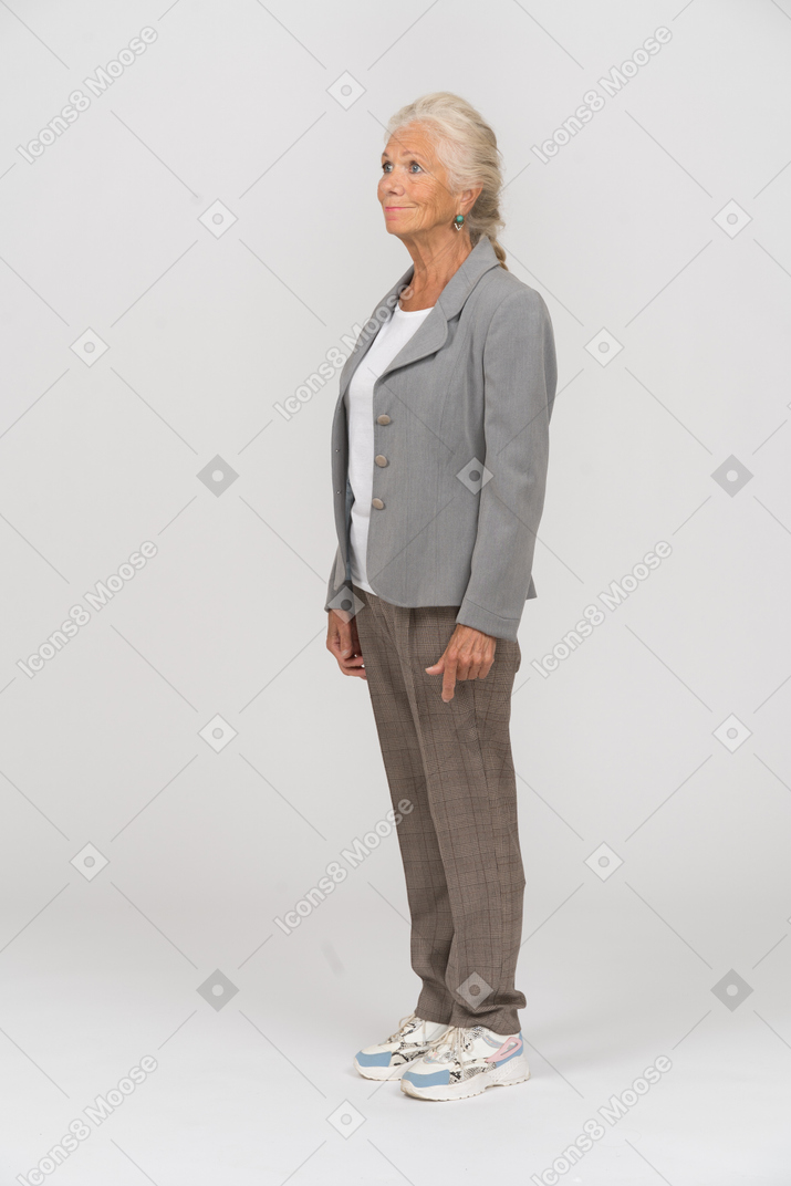 프로필에 서 있는 회색 재킷을 입은 노부인