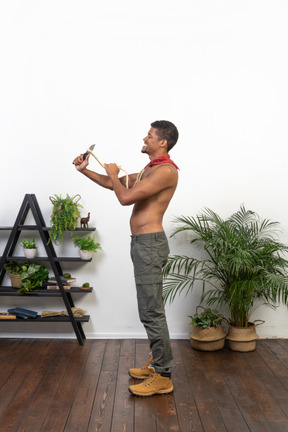 Side view of athletic man cutting rope with a blade