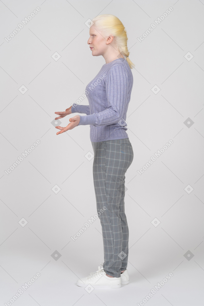 Side view of young woman shrugging